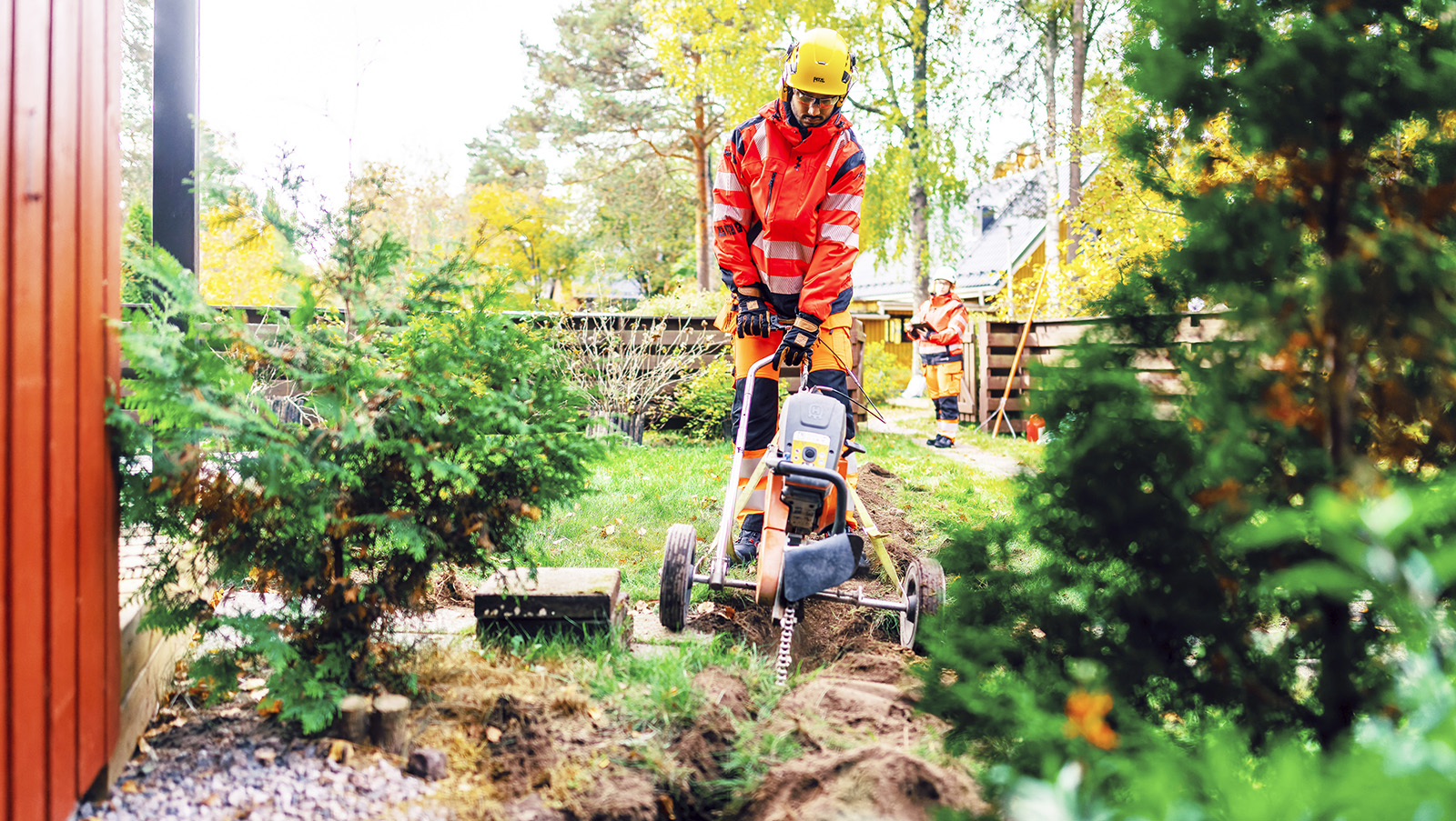 Mies asentaa valokuitukaapelia maan alle